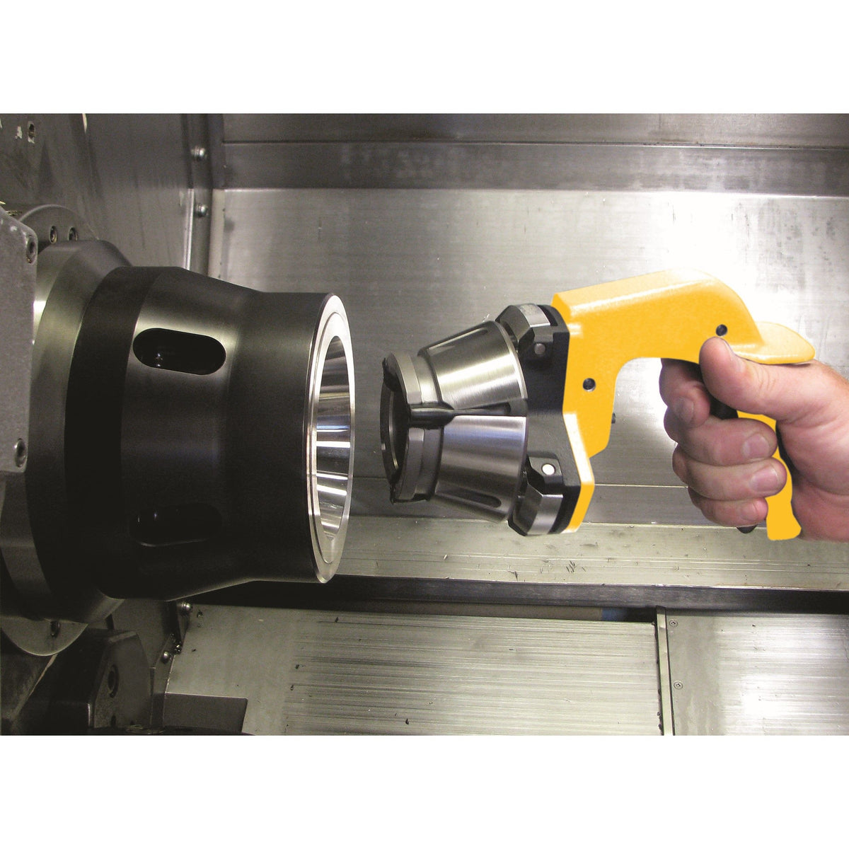Royal Quick-Grip Collet Installation Tool 44098, hand holding the tool with a collet in front of a chuck inside a machine
